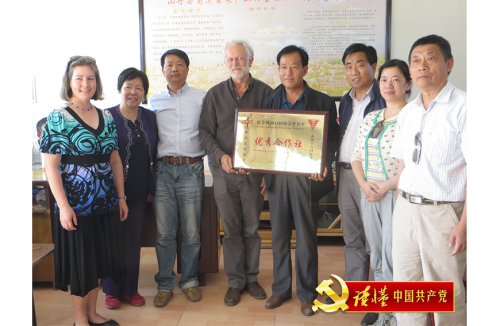2012年, 荣大伟(左四)在甘肃省张掖市山丹县代表新中友好协会与工合国际向一家农村合作社颁奖.png